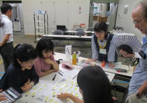 紙を指差し意見交換をしている様子